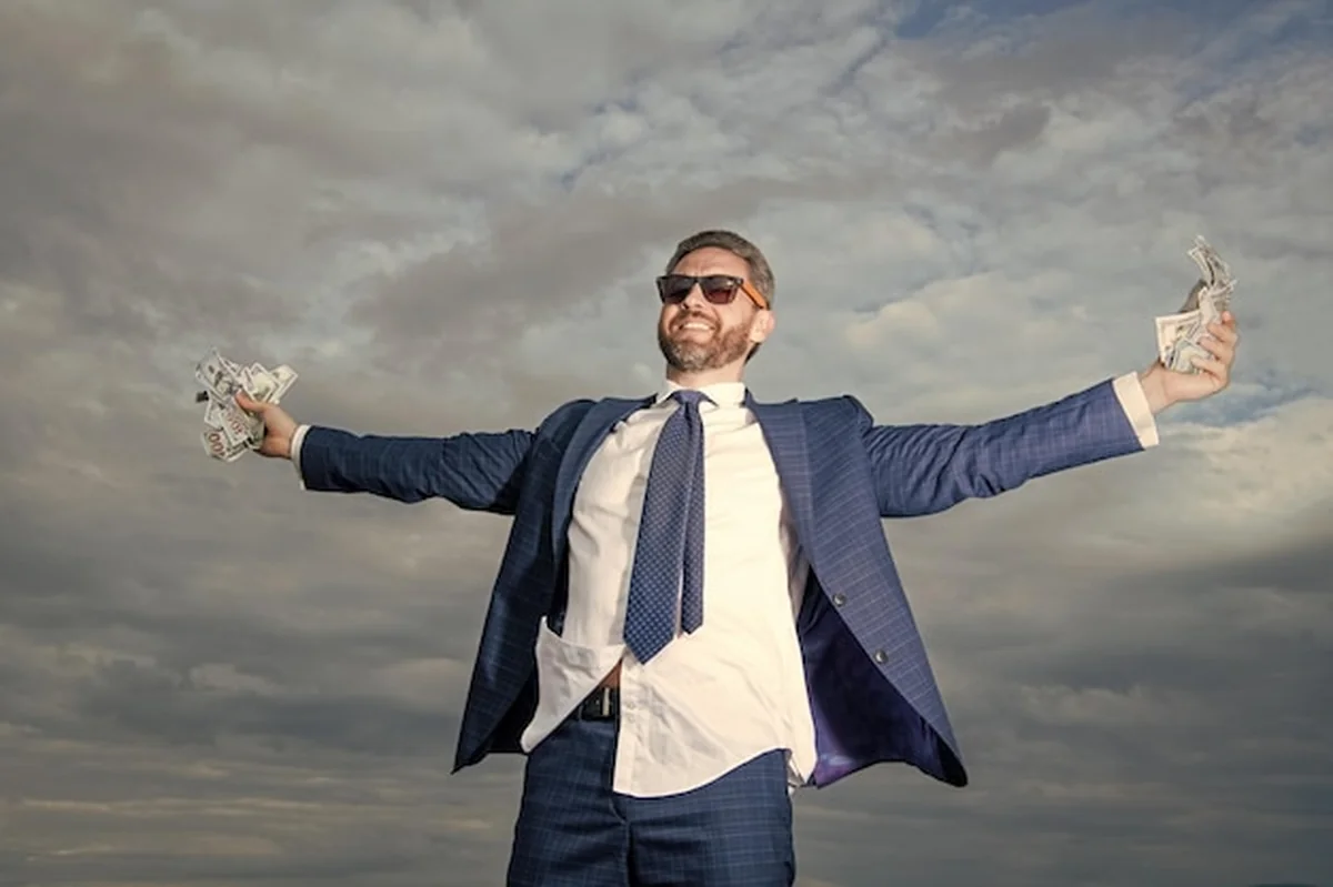 Szczęśliwy milioner z pieniędzmi w tle