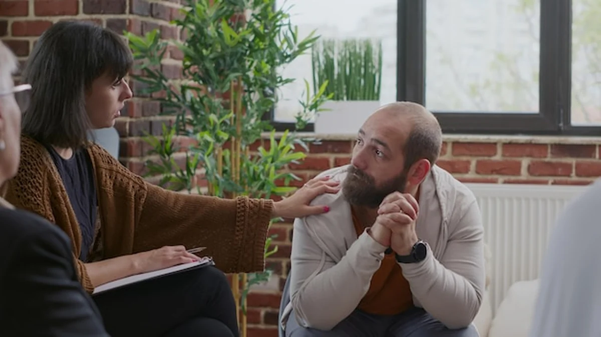 Drżąca osoba w kręgu terapeutycznym podczas sesji grupowej