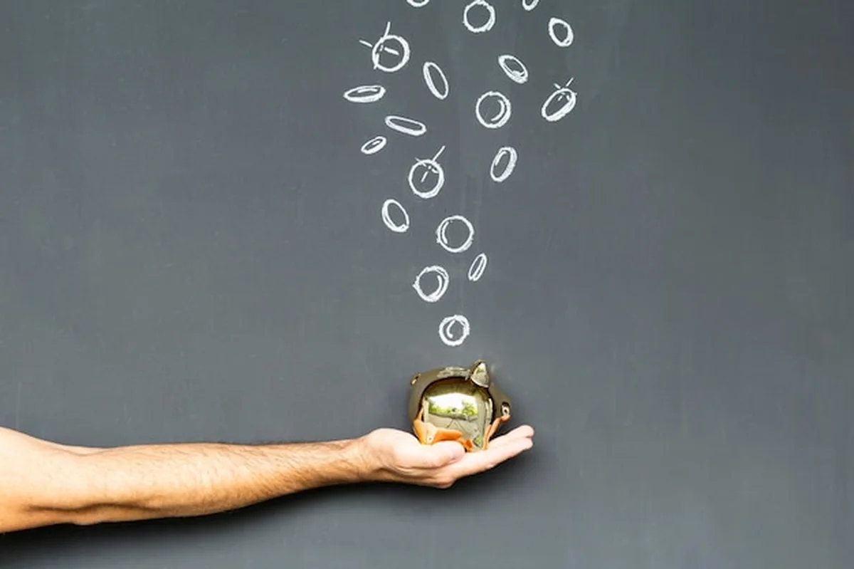 Złota świnka i monety przed tablicą